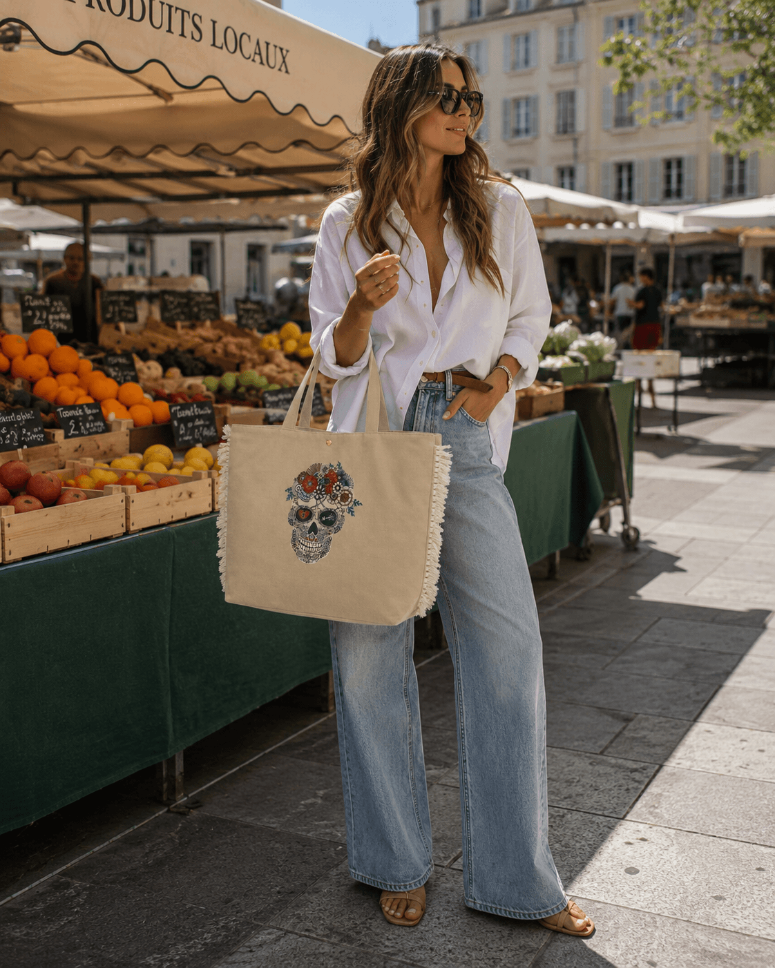 Shoulder Bag Henry – Frau trägt beige Boho-Shopper mit Sugar Skull Aufdruck zum weißen Hemd und Wide-Leg-Jeans auf einem Wochenmarkt | LiBEAU