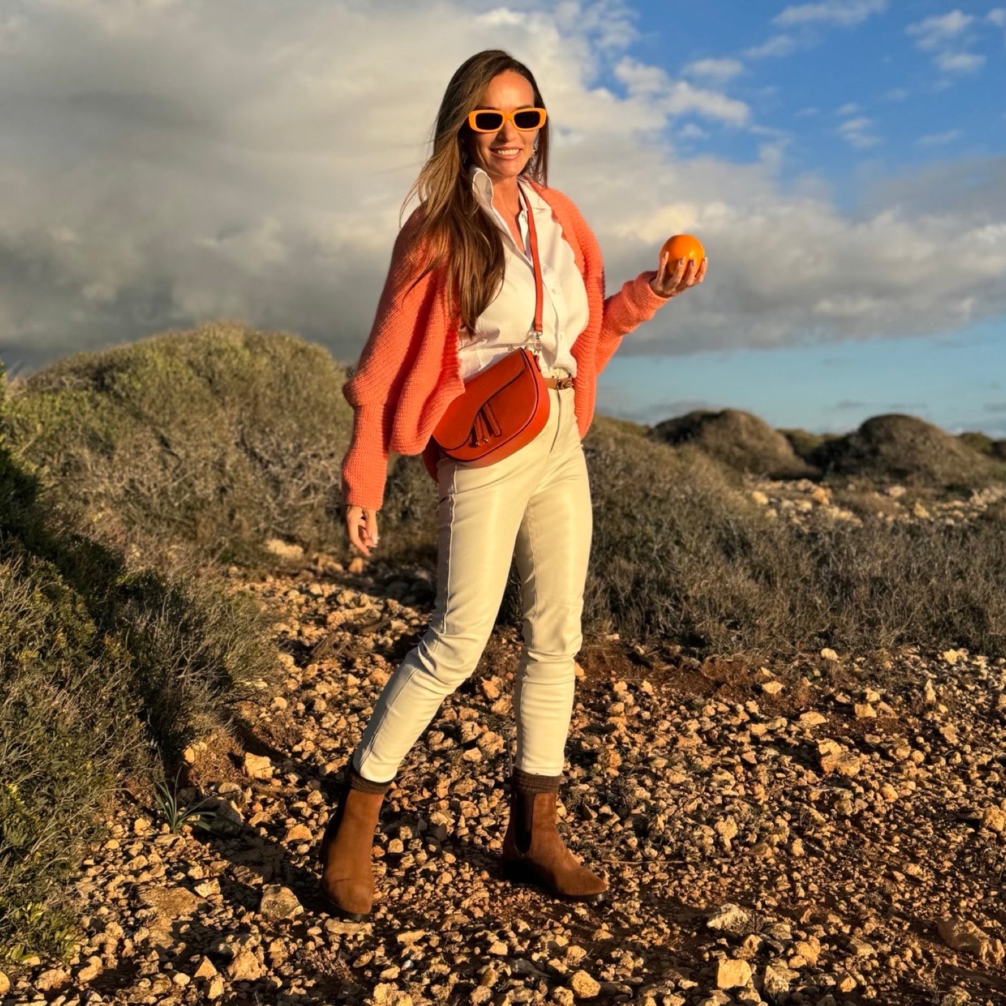Chelsea Caramel Boots – LiBEAU Damen trägt Braun Cognac Wildleder Chelsea Boots zu weißen Jeans und Lachs-Cardigan auf Mallorca, fröhlicher abenteuerlicher Sommer Editorial Look | LiBEAU
