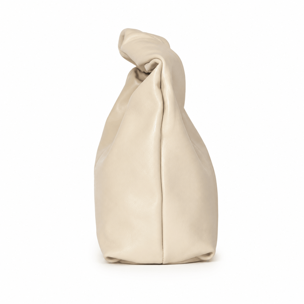 Crossy Clutch – LiBEAU Detailansicht Seitenansicht cremefarbene Kunstleder-Clutch aufrecht stehend mit getwisteten Knoten-Henkel, schlanke skulpturale Silhouette | LiBEAU
