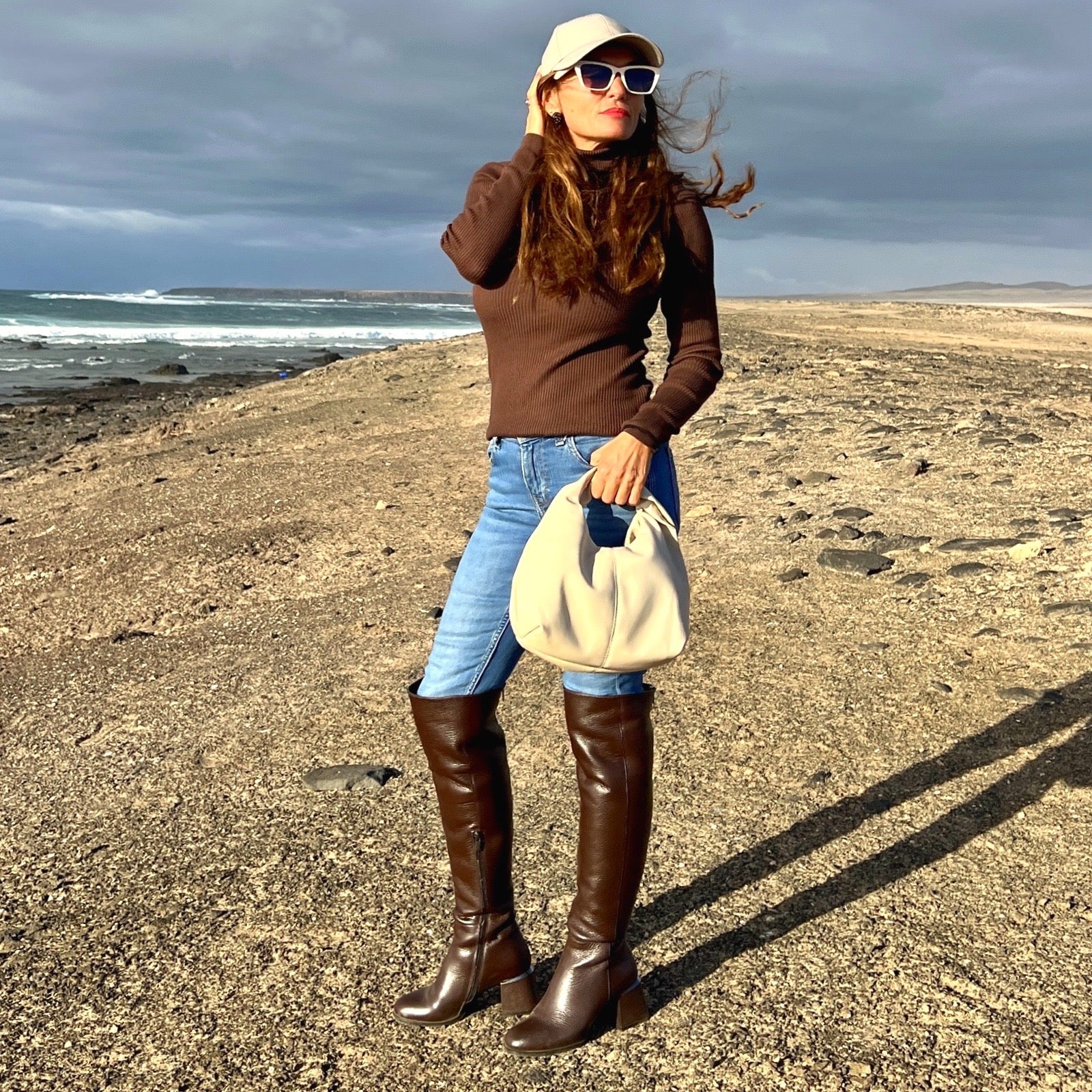 Grace Stiefel – LiBEAU Damen trägt Dunkelbraun Leder Overknee Stiefel zu Jeans am Strand, lässiger cooler Editorial Look | LiBEAU
