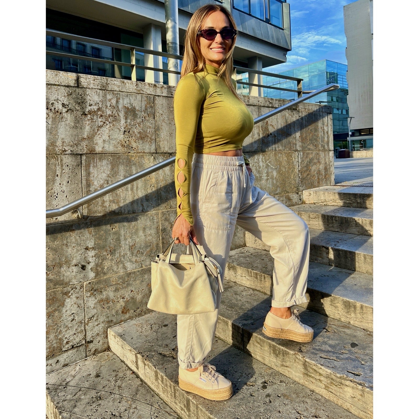 Jasmine Bag Panna – Frau trägt cremefarbene Handtasche im Casual-Look auf Treppe | LiBEAU
